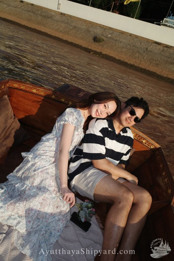 Ayutthaya boat tour, romantic river cruise, traditional Thai dress, Chao Phraya River, Ayutthaya Shipyard Couple smiling on Ayutthaya boat tour with flowers, romantic river cruise on Chao Phraya River by Ayutthaya Shipyard