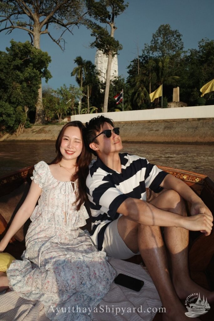 Ayutthaya boat tour, romantic river cruise, traditional Thai dress, Chao Phraya River, Ayutthaya Shipyard Couple smiling on Ayutthaya boat tour with flowers, romantic river cruise on Chao Phraya River by Ayutthaya Shipyard
