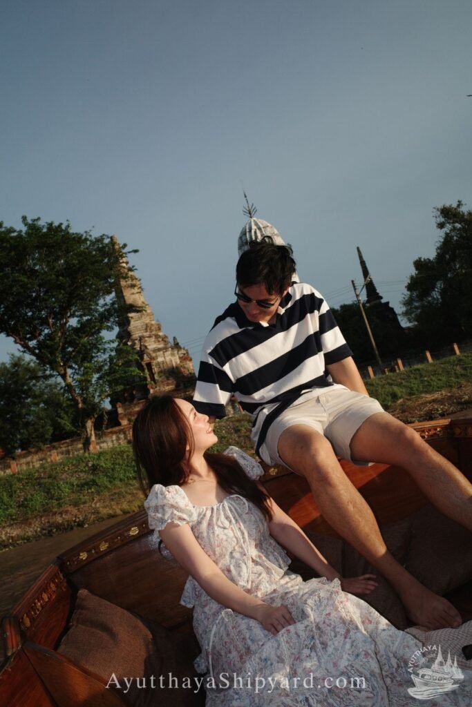 Ayutthaya boat tour, romantic river cruise, traditional Thai dress, Chao Phraya River, Ayutthaya Shipyard 
Couple smiling on Ayutthaya boat tour with flowers, romantic river cruise on Chao Phraya River by Ayutthaya Shipyard
