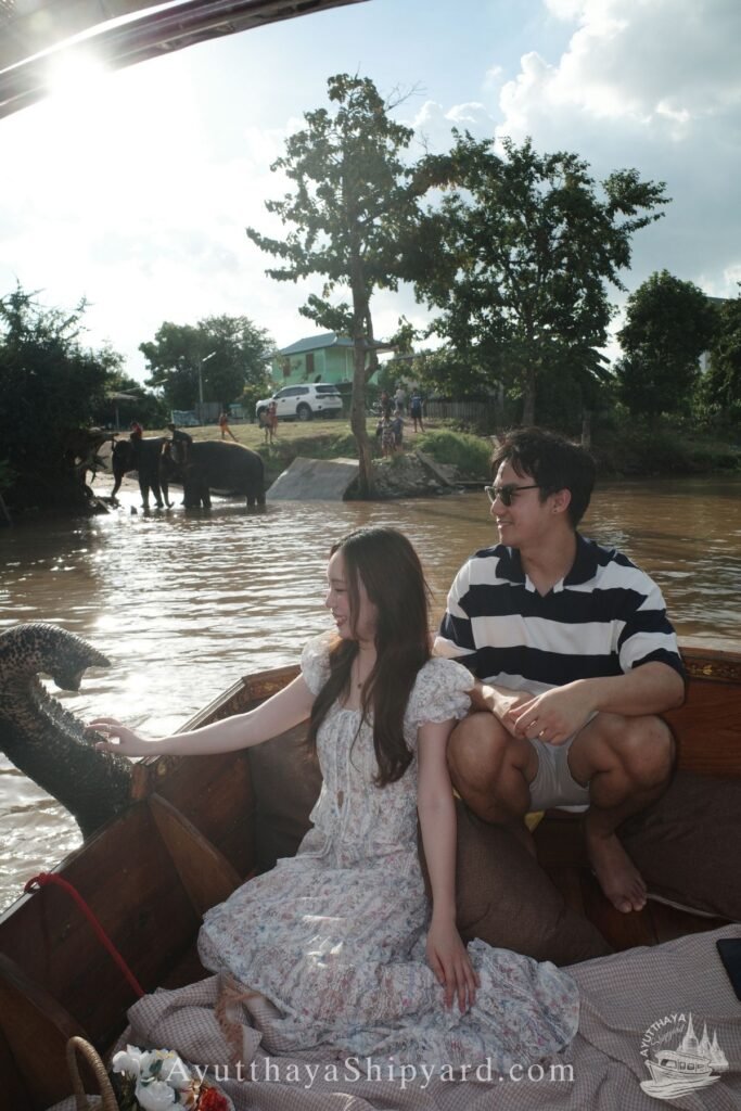Couple enjoying a private Ayutthaya river cruise, touching an elephant by the riverside, unique cultural experience in Thailand Ayutthaya River Cruise Ayutthaya Private Boat Tour Ayutthaya Island Cruise Elephant & River Life Cruise Ayutthaya Ayutthaya Riverside Photography ล่องเรืออยุธยา ล่องเรือเจ้าพระยา อยุธยา ล่องเรือส่วนตัว อยุธยา ล่องเรืออยุธยา ถ่ายรูป